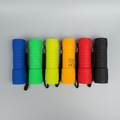 Colorful flashlights lying in a row on a grey background.