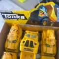 A box of Tonka classic toy trucks, featuring a yellow dump truck in the blister packaging above several yellow construction vehicles in clear plastic wrapping.